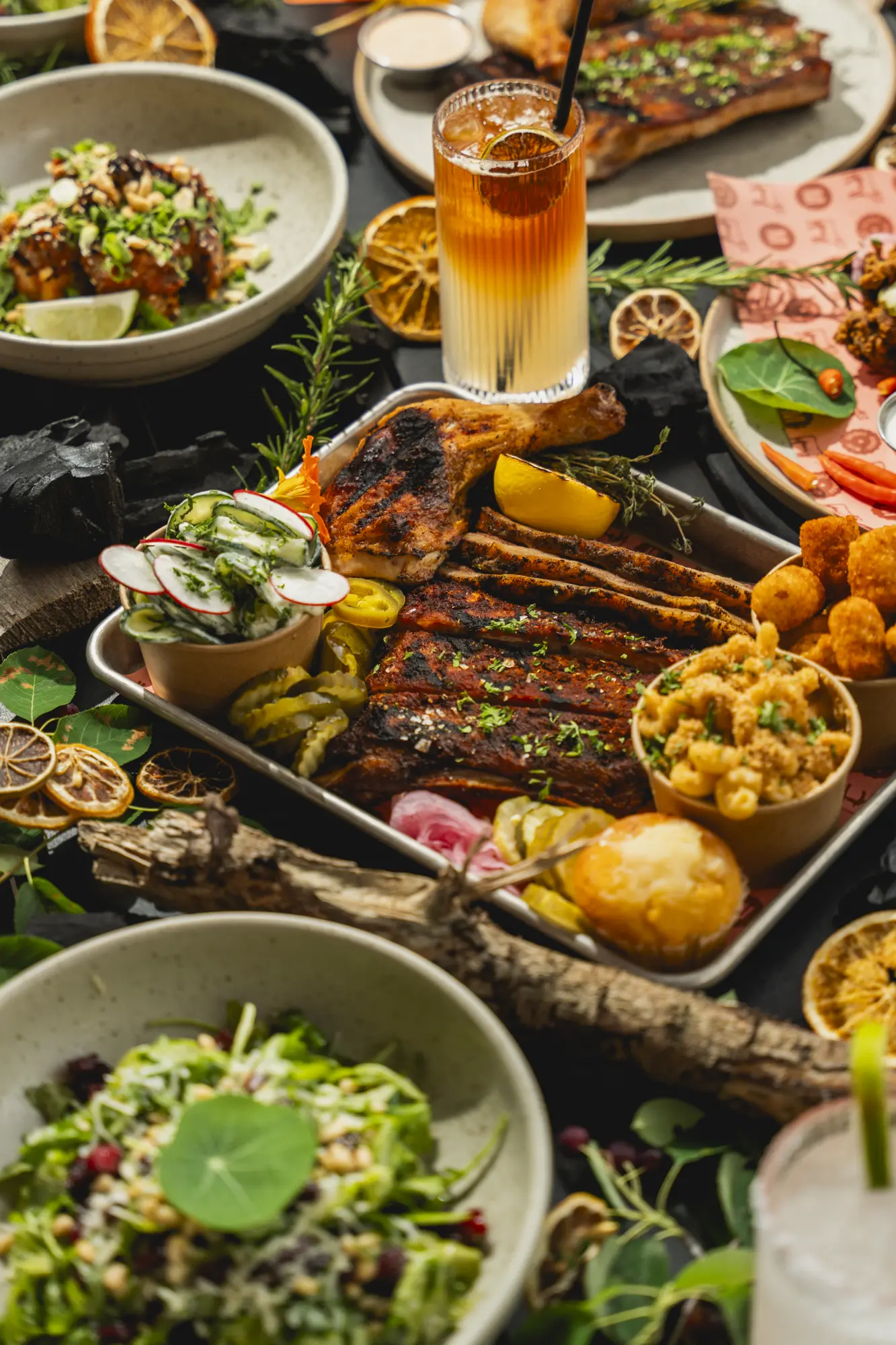 A smokehouse takeout feast with ribs, chicken, sides, and drinks